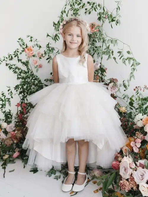 model is wearing a high low flower girl dress