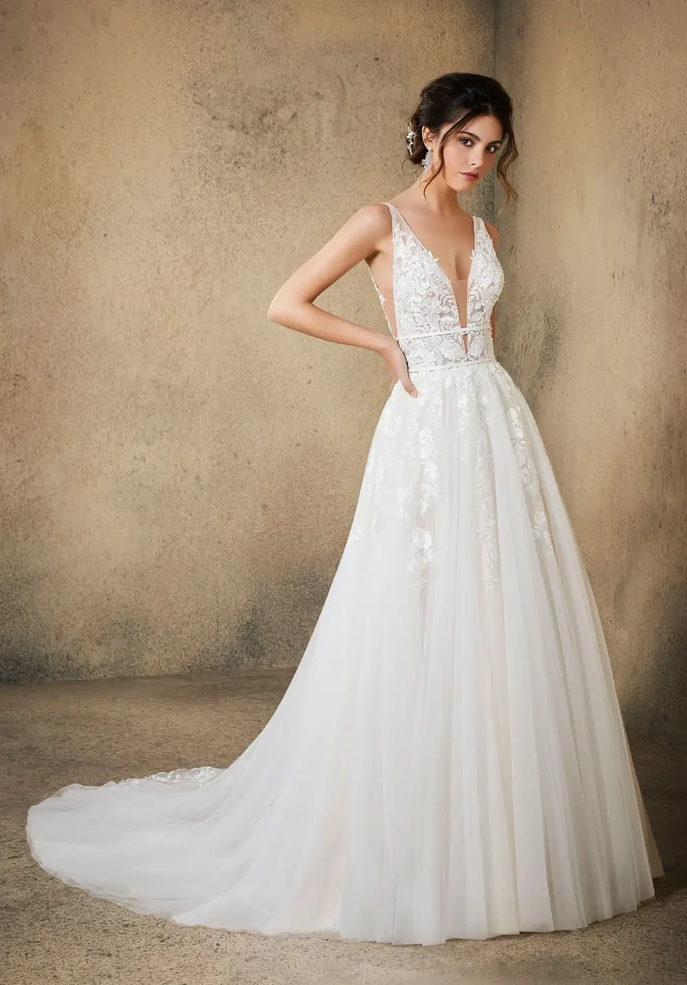 model is wearing a sleeveless open back wedding dress