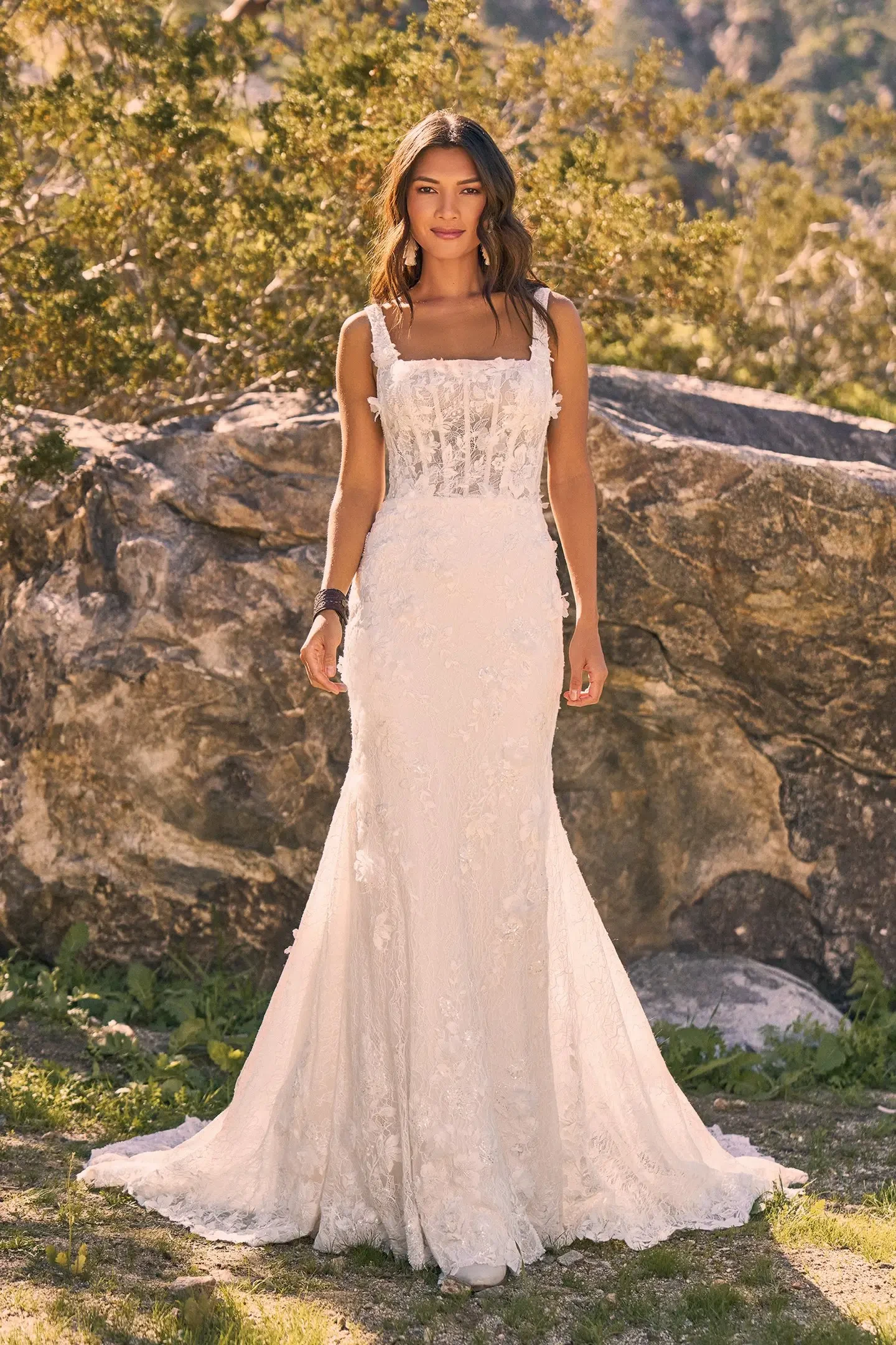 Model is wearing a sleeveless fit and flare lace wedding dress with a square neckline