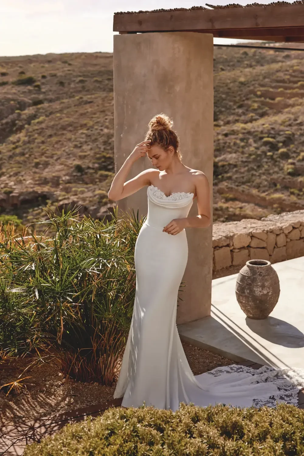 model is wearing a strapless bridal gown with detachable long sleeves