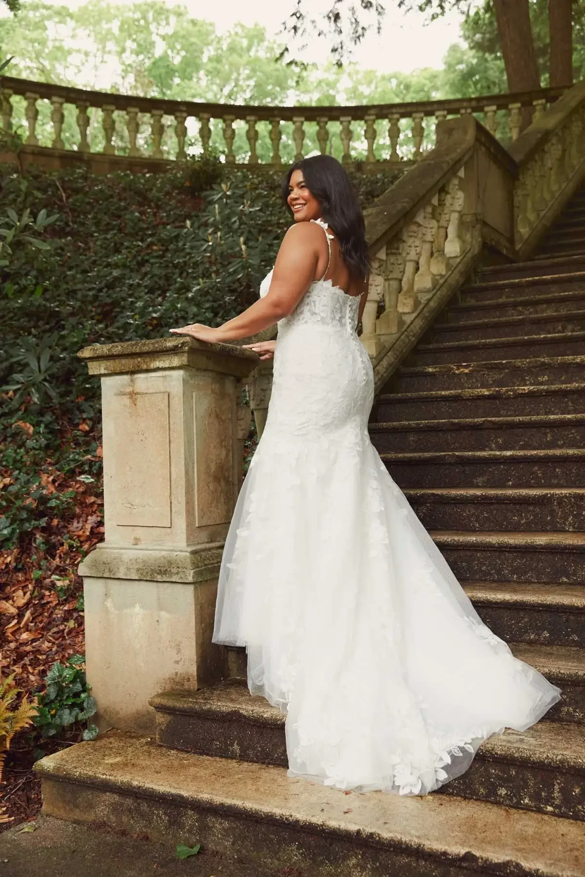 Model is wearing a sleeveless fit and flare plus size wedding dress