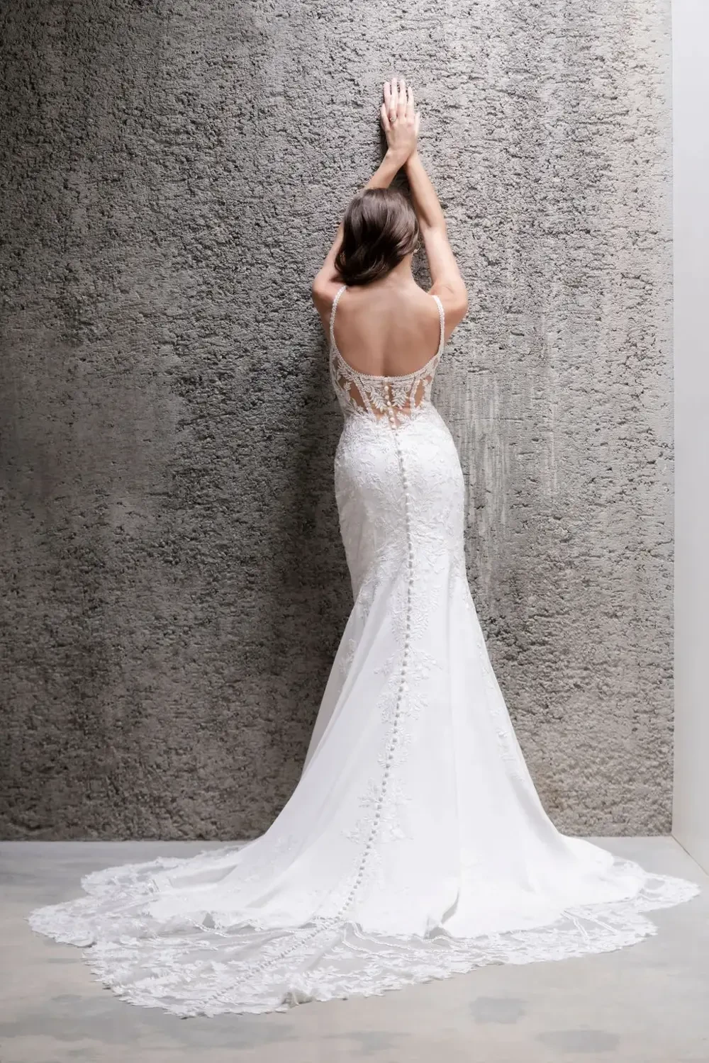 model is wearing a sleeveless open back bridal gown