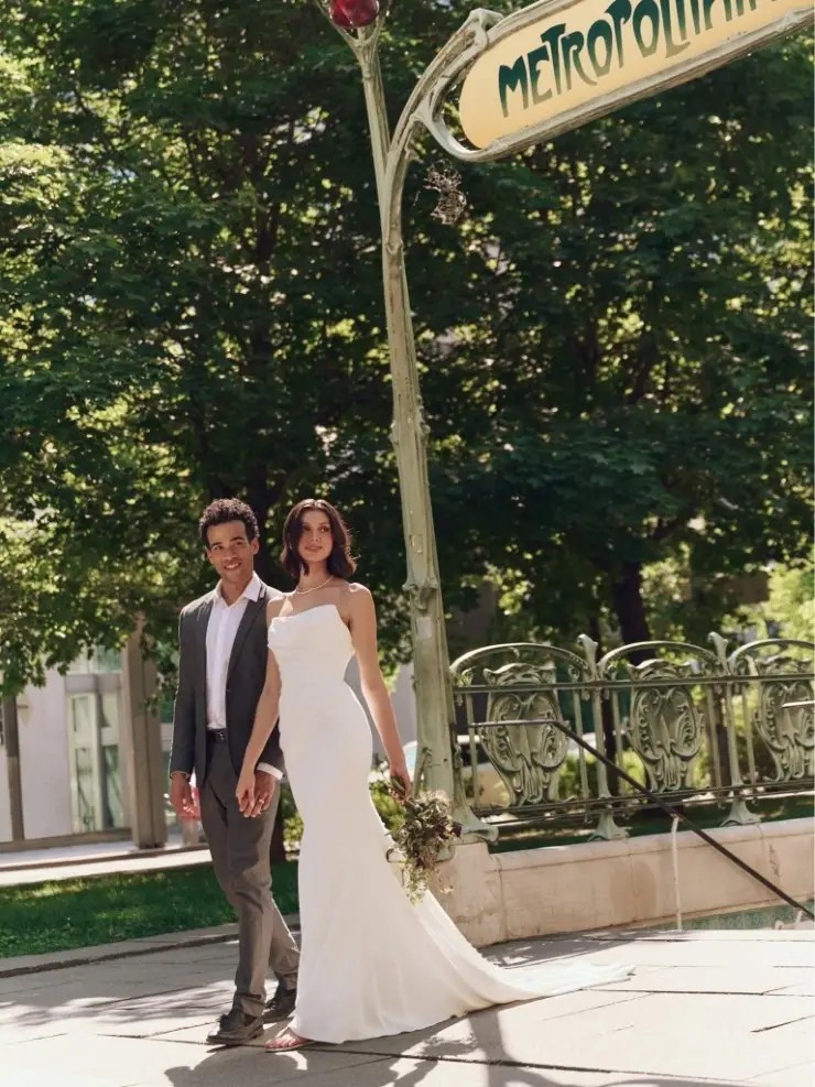 Model is wearing a strapless crepe cat eye neckline bridal gown by rebecca ingram